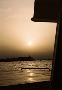 The view from a ferry deck heading toward Giudecca across the Venetian lagoon under a slightly overcast sunset. Image supplied.